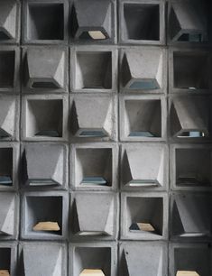 concrete cubes are stacked on top of each other to create a wall display for books