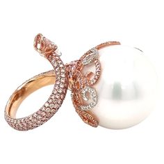 Something from our private collection. Experience the epitome of elegance and luxury with this exceptional pink gold ring by Autore. At its heart, a magnificent 21mm South Sea pearl takes center stage, exuding timeless beauty. A symphony of diamonds elegantly dances around the pearl – a total of 101 pieces of 0.29-carat diamonds, combined with a 0.41-carat diamond, two 0.42-carat diamonds, and a final 0.42-carat diamond. This masterpiece is a harmonious blend of exquisite craftsmanship and rare, precious elements. Each diamond is meticulously placed to enhance the ring's splendor, creating an enchanting display of brilliance and fire. From the luminous pink gold setting to the resplendent South Sea pearl and the sparkling diamonds, this ring embodies Autore's commitment to crafting excepti Pink Gold Ring, Pink Gold Rings, Sea Pearl, South Sea Pearls, Center Stage, Gold Set, Sparkle Diamonds, Pearl Ring, Cocktail Rings