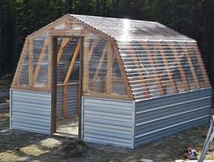 a small metal building with a wooden roof