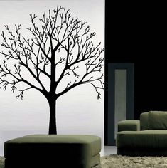 a living room with a couch and a tree decal on the wall