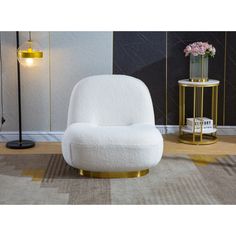 a white chair sitting on top of a rug next to a lamp