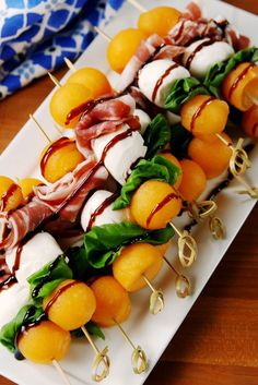 a white plate topped with oranges and meat on skewers