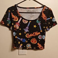 Awesome Sailor Moon Crop Top! The Garment Features Wands, Stars And Sailor Moon Text In An All Over Print. It's Made With 95% Polyester And 5% Spandex. There Are No Flaws To The Shirt. The Measurements Are: Pit To Pit: 15 Inches Length Of Top Of Neckline To Bottom Hem: 16 Inches. Sailor Moon Crop Top, Fitted Black Cartoon Print Tops, Fitted Black Top With Cartoon Print, Fitted Black Tops With Moon Print, Casual Multicolor Star Print Top, Casual Multicolor Tops With Star Print, Moon Text, Moon Crop Top, Sailor Moon Shirt