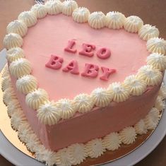 a heart shaped cake with the words leo baby written in frosting on it's side