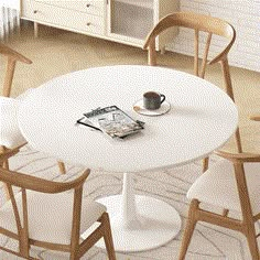 a white table with chairs around it and a magazine on the table next to it