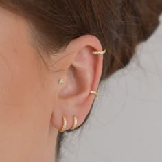 an ear with three different types of piercings on the top and bottom of it