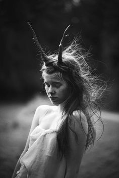 black and white photograph of a girl with horns on her head