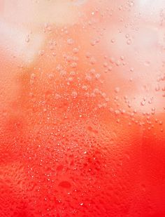 water drops on the surface of a red liquid