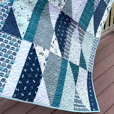 a blue and white quilt on a wooden deck