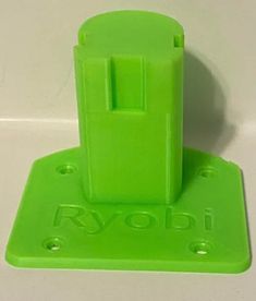 a green plastic device holder on a white surface with the word roobi printed on it