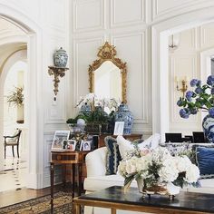 a living room filled with lots of furniture and flowers in vases on the coffee table