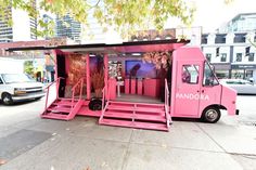 a pink food truck parked in front of a building