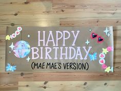 a happy birthday sign on a wood floor with butterflies and hearts around it that says mae's version