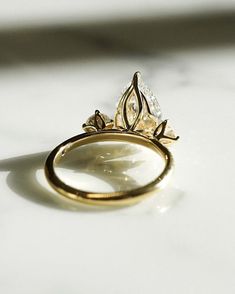 a close up of a gold ring on a white surface with light shining through it