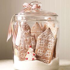 a glass jar filled with gingerbread cookies on top of a table