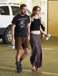 a man and woman are walking together in the parking lot