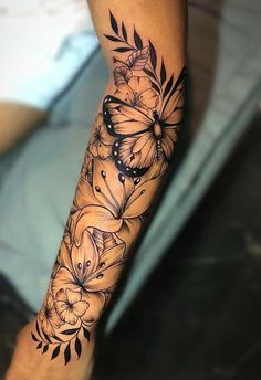 a woman's leg with flowers and butterflies on it