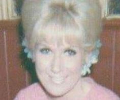 an old photo of a woman with blonde hair and blue eyes smiling at the camera