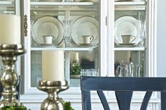 a china cabinet with candles and plates on it