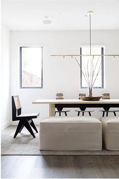 a modern dining room with white walls and wood flooring