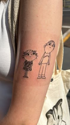 a woman's arm with a drawing of two people on it, one is holding the