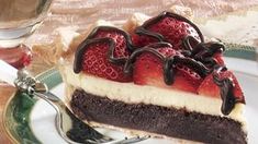 a piece of cake with chocolate and strawberries on top is sitting on a plate