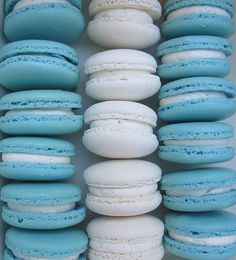 there are many blue and white macaroons in the box