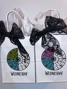 two bags with black lace on them and the words wednesday in rainbow colors