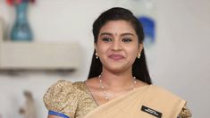 a woman in a sari is smiling for the camera