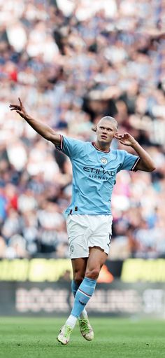 a soccer player in action on the field with his arms stretched out and hands outstretched