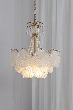 a chandelier hanging from the ceiling in a room with white walls and curtains