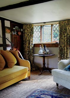 a living room with two couches and a table in front of the window,