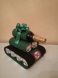 a birthday cake made to look like a tank with a bottle of wine on top