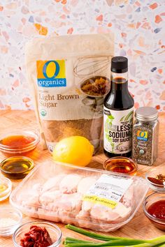 ingredients to make chicken broth laid out on a wooden table with oranges, lemons and seasonings