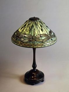 a lamp that is sitting on top of a table with a glass shade over it