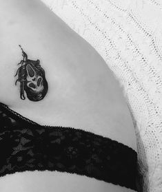 a woman's stomach with a tattoo on the side of her body and a mask