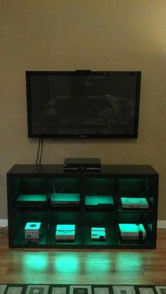 a flat screen tv sitting on top of a wooden entertainment center in a living room