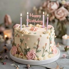 a birthday cake decorated with flowers and candles