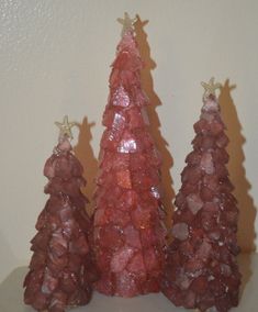 three small red trees sitting on top of a table