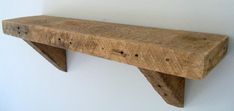 a wooden shelf mounted to the wall with two brackets on each side and one is made out of wood