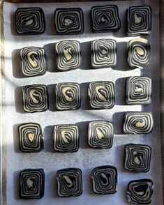 some black and white squares are in a tray on the table, with gold swirls