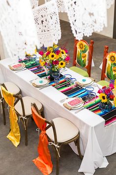 the table is set with colorful plates and napkins