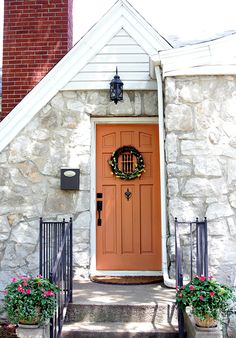 the front door of a house with potted plants