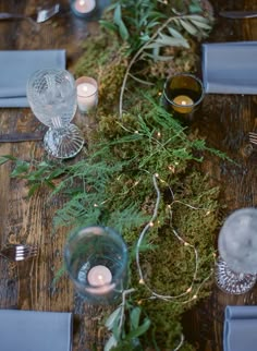 the table is set with candles and greenery