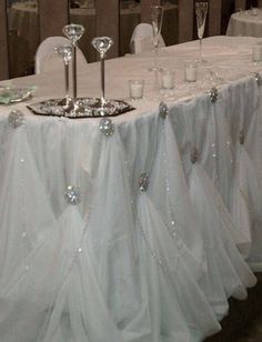 the table is set with white linens and silverware