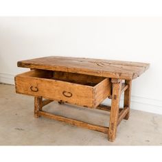 an old wooden table with two drawers on it's legs and one drawer open