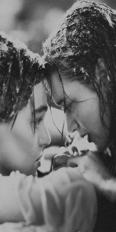 two people are kissing each other while wearing headbands and hair in black and white