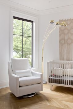 a baby's room with a rocking chair, crib, and large window