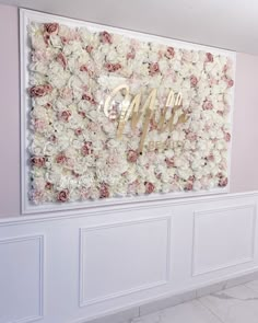 a white wall with flowers and the word mr and mrs in gold foil on it