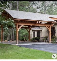 an image of a house with a carport in the driveway and trees around it